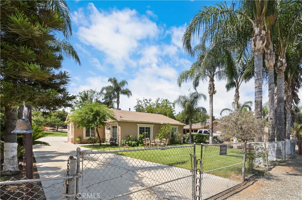 a view of a house with a yard and palm trees