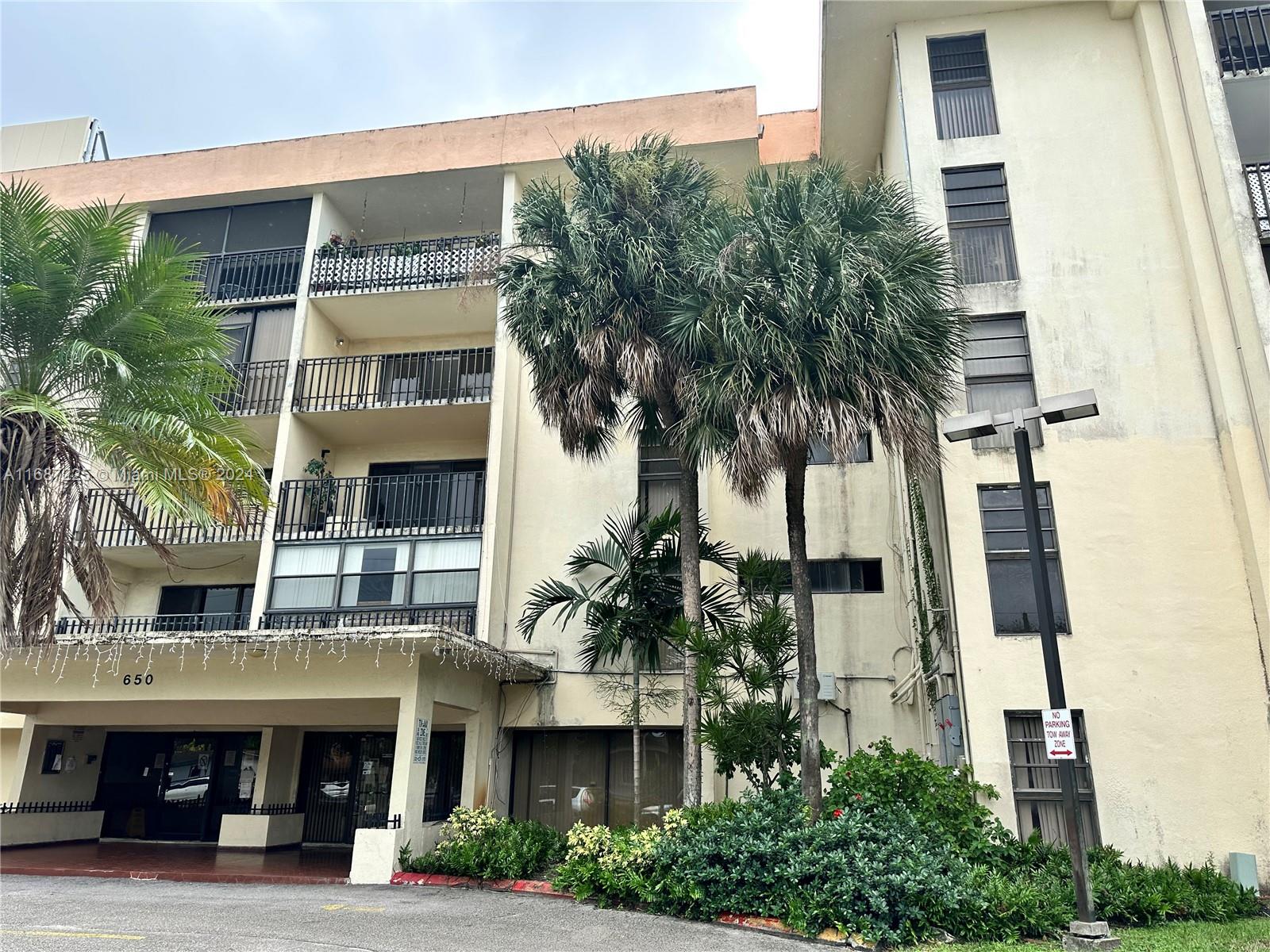 a front view of a building with a garden