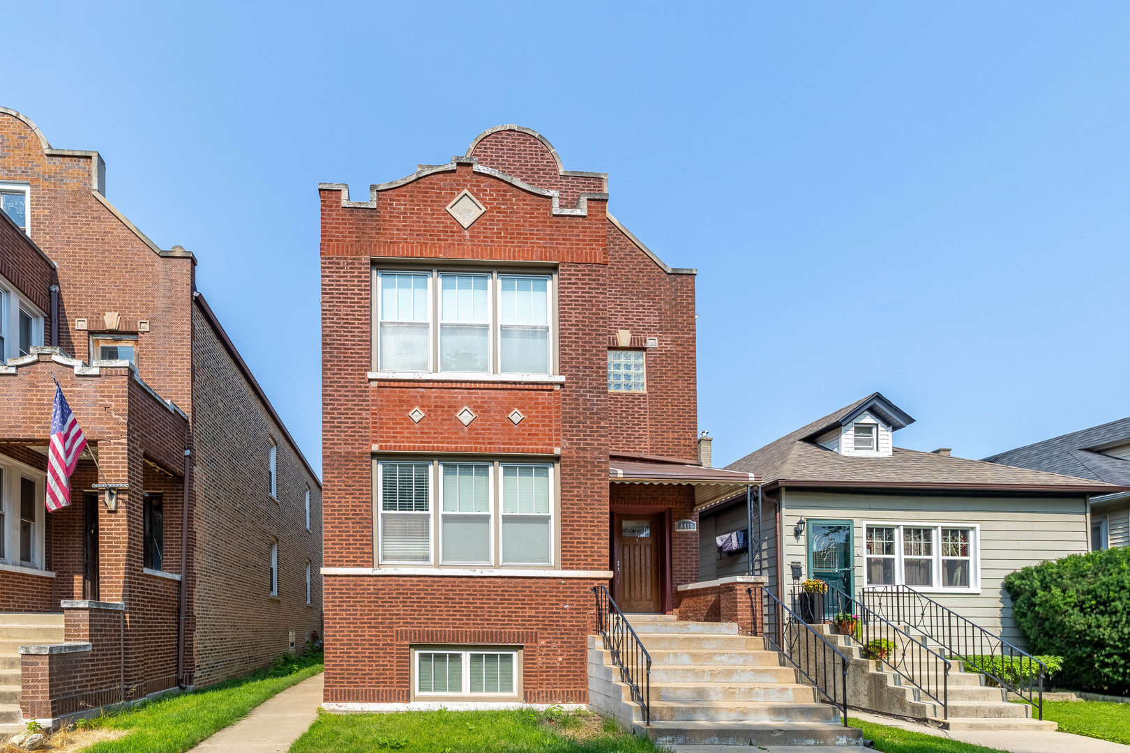 a front view of a residential apartment building with a yard