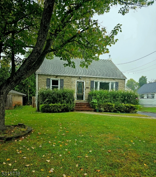 a front view of a house with a yard and trees