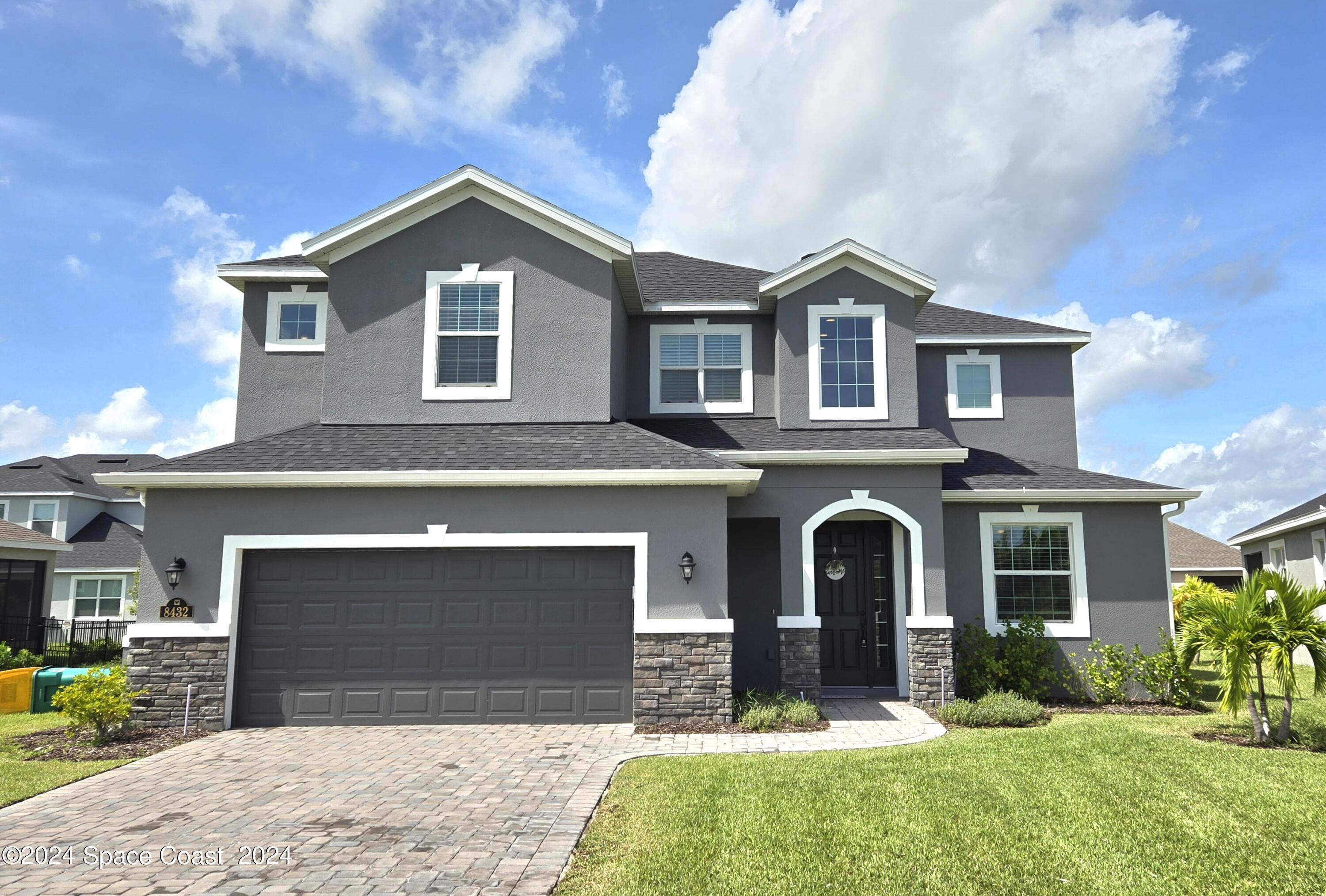 a front view of a house with a yard and garage