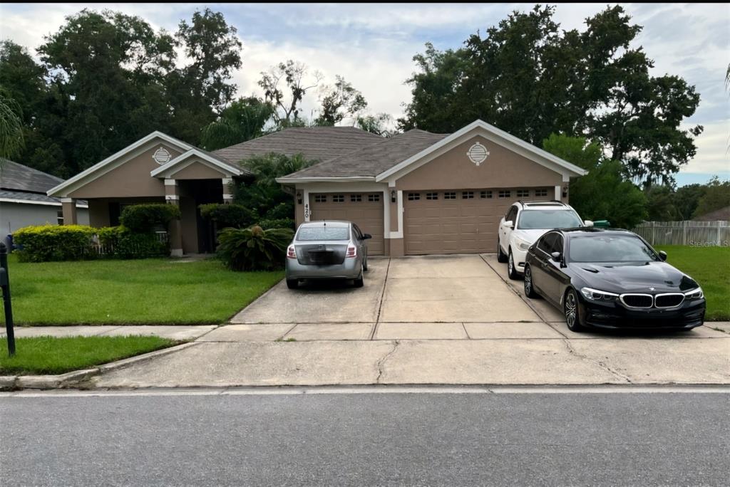 a car parked in front of a house with yard