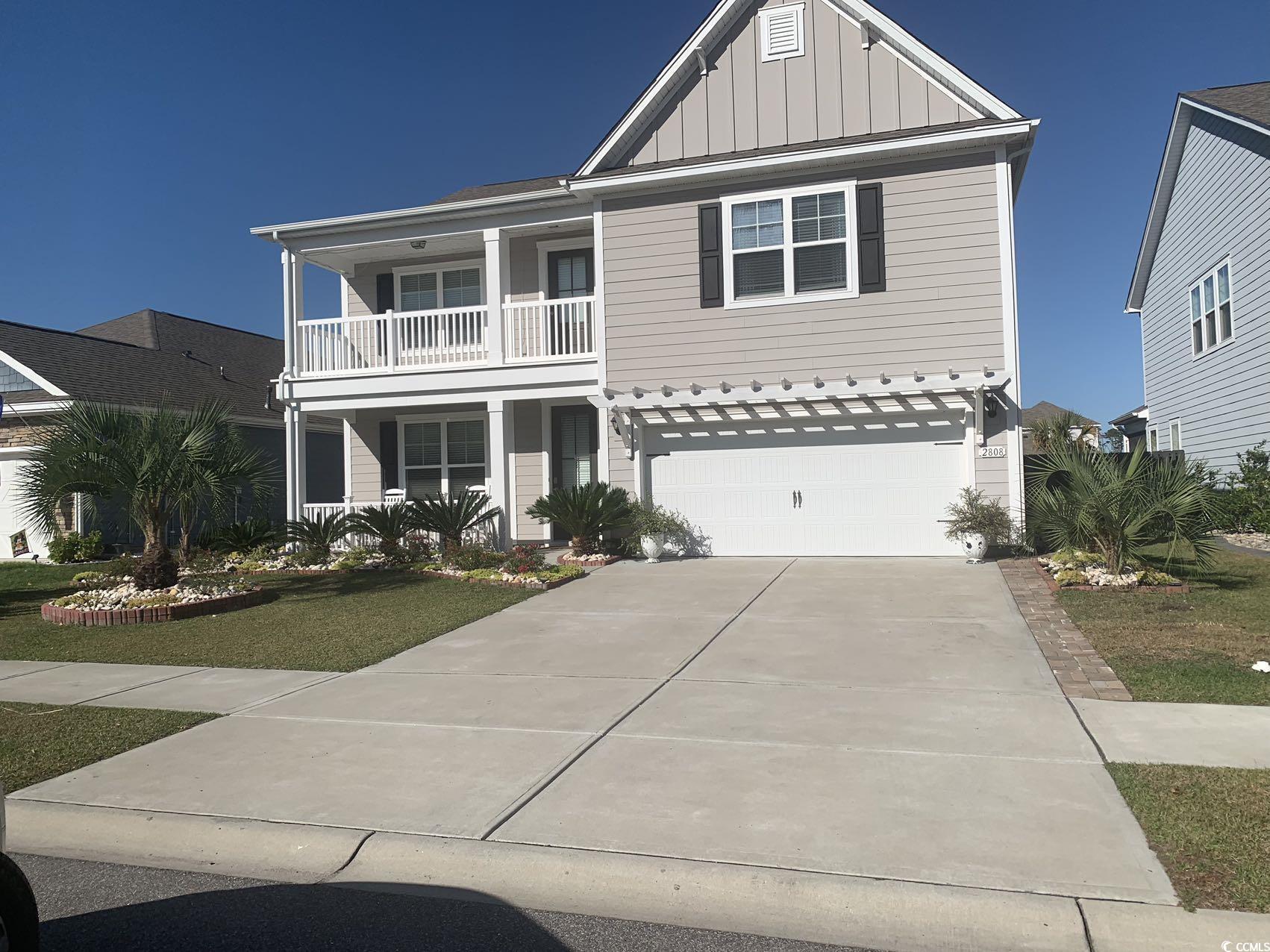 View of front of home featuring a garage, a balcon