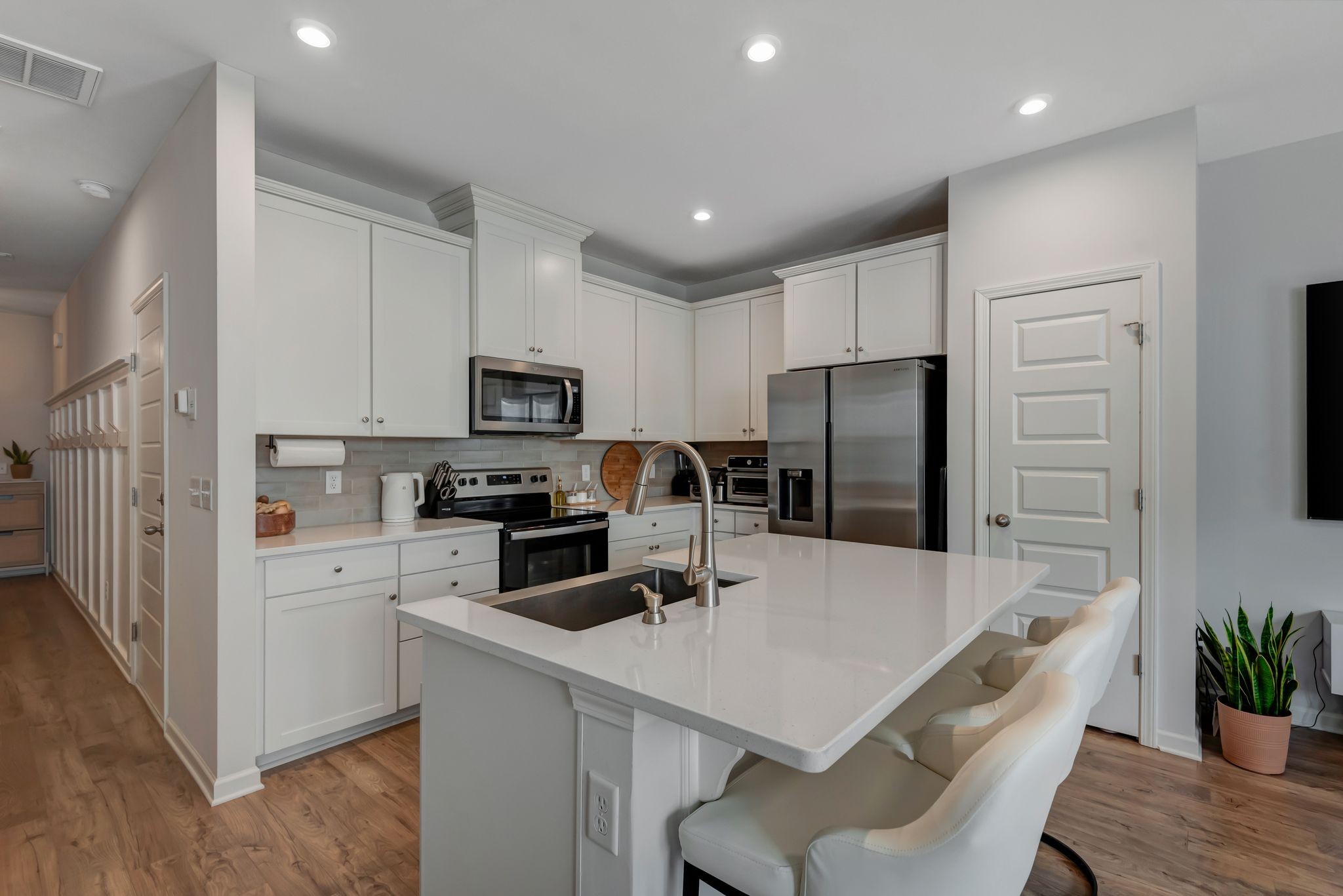 a kitchen with kitchen island a refrigerator stove microwave and cabinets