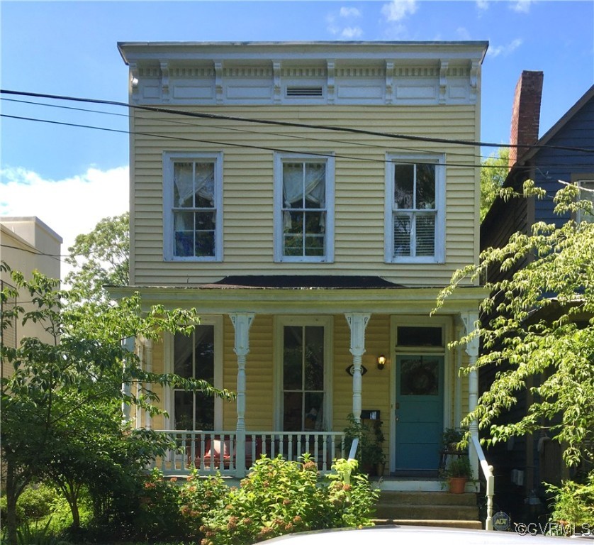 a view of a house with potted plants and a tree