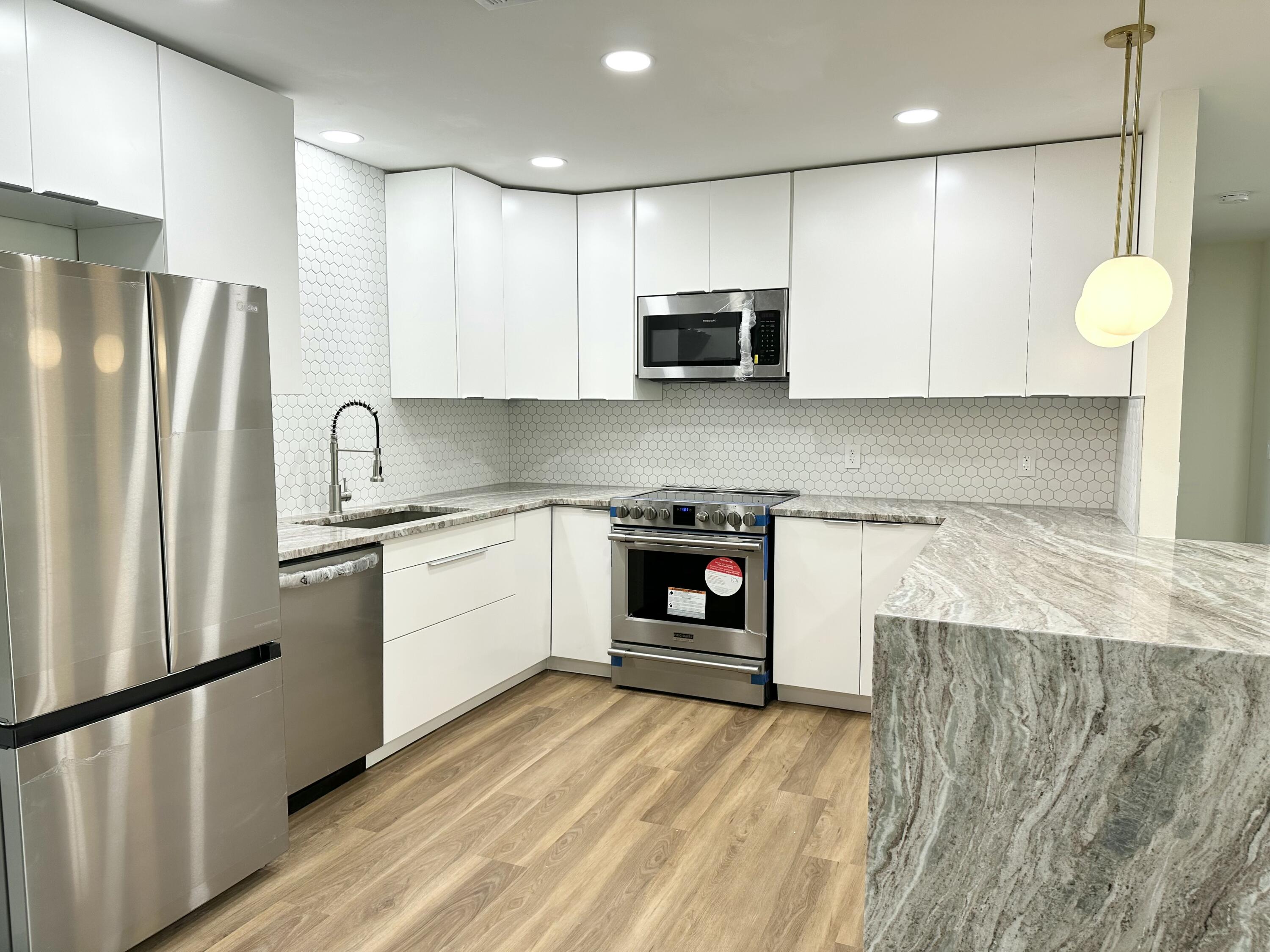 a kitchen with stainless steel appliances a refrigerator sink and microwave