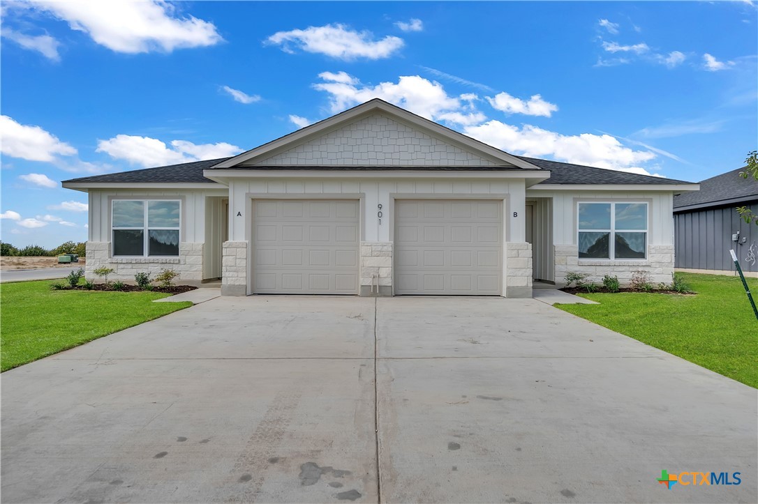 a view of house with yard and a garage