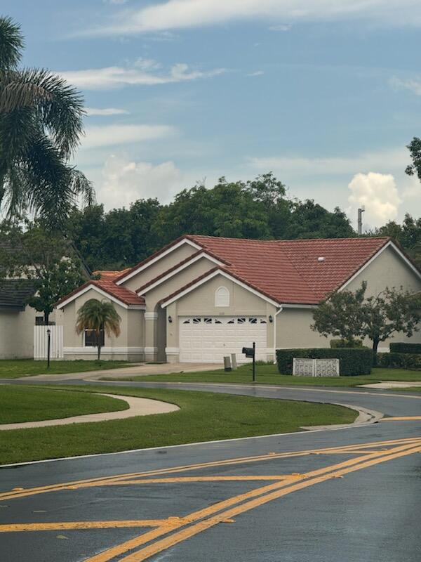 a view of big house with a big yard and large trees