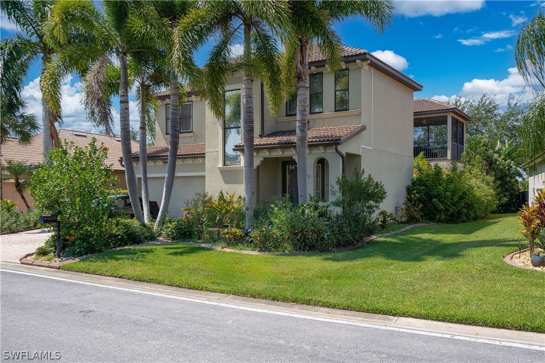 a view of a white house next to a yard with palm trees