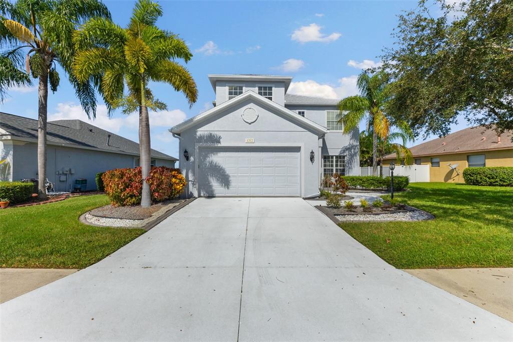 a front view of a house with a yard and a garage