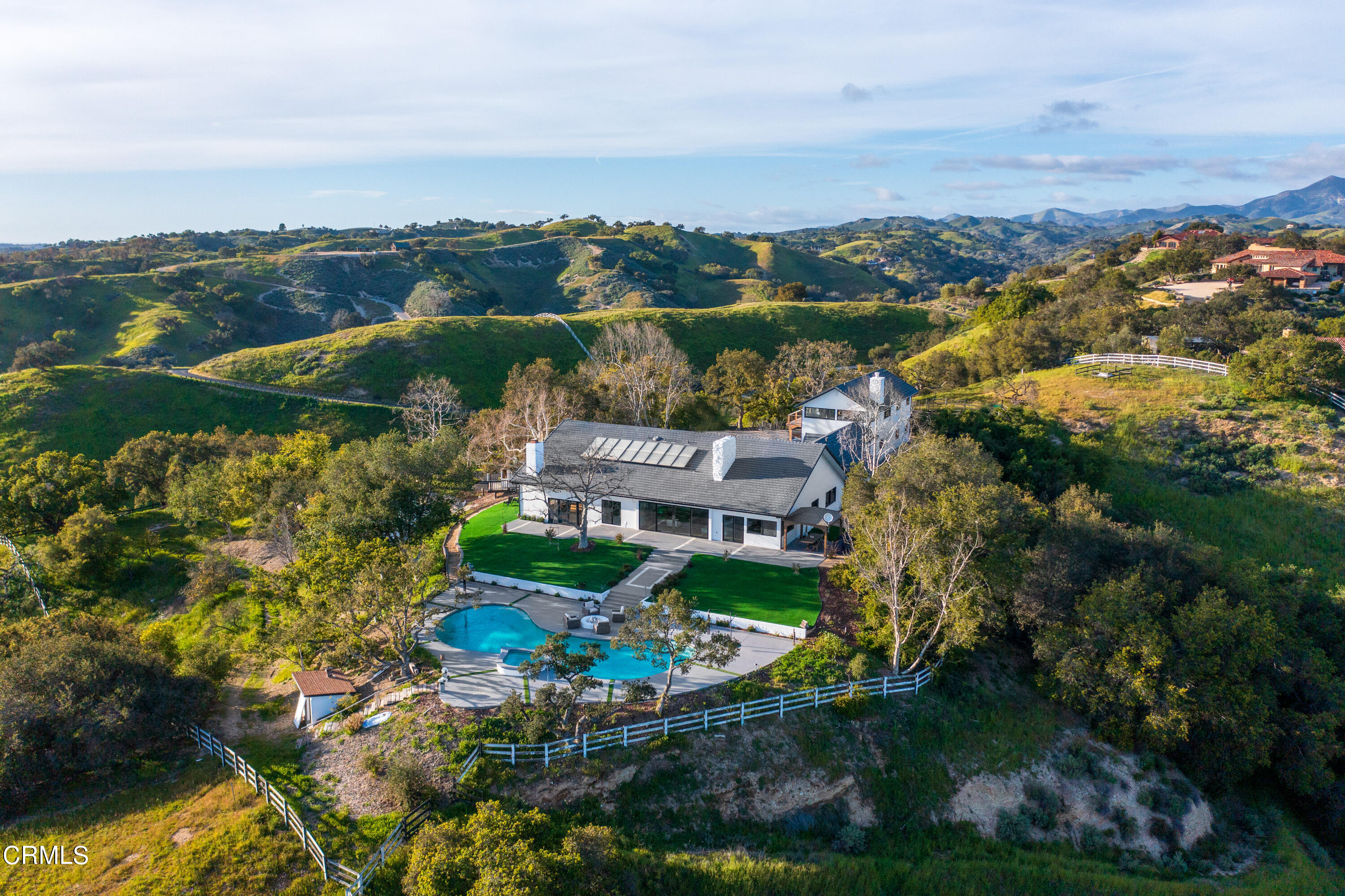 an aerial view of a house with a garden and lake view