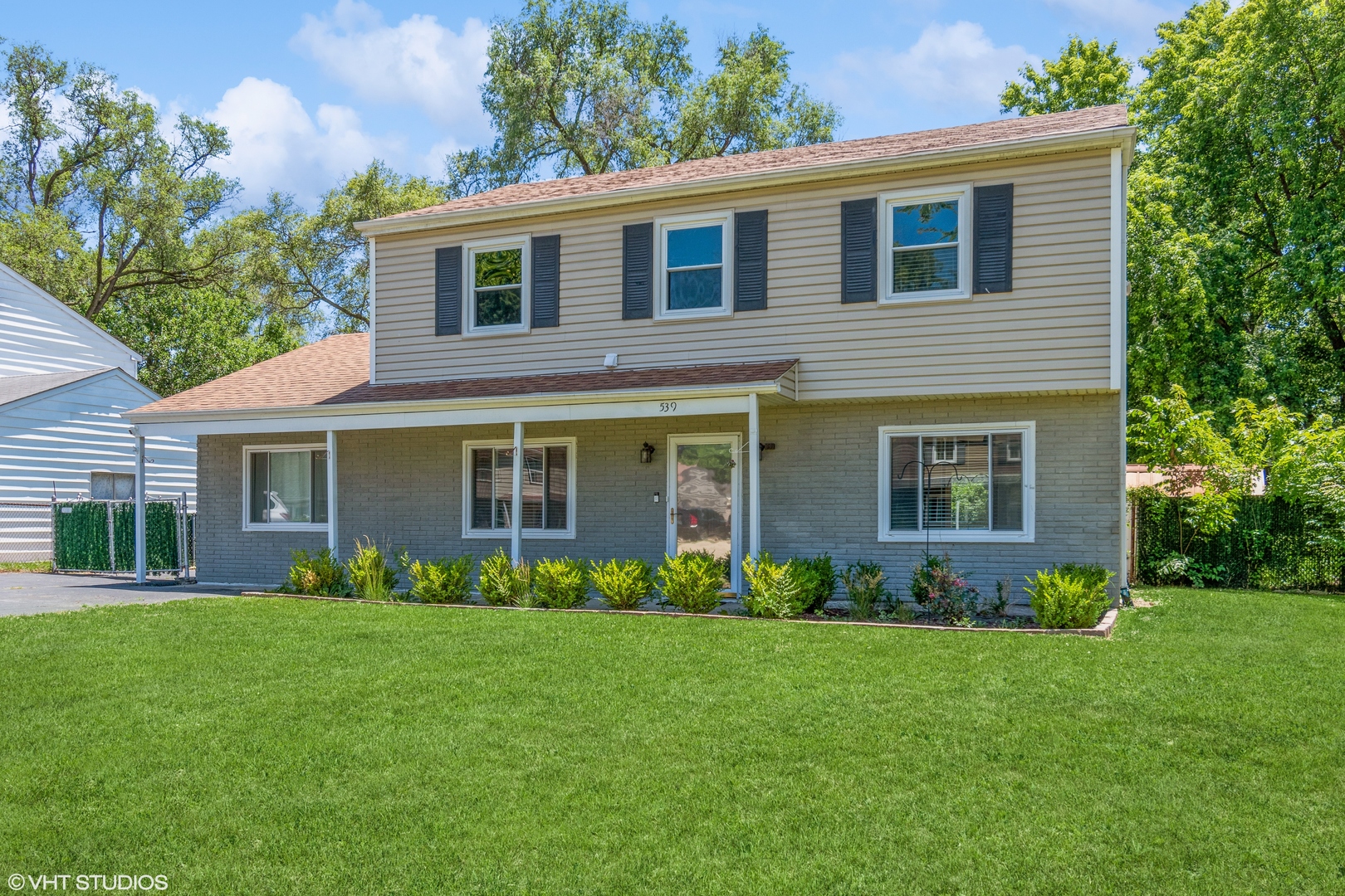 a front view of house with yard and green space