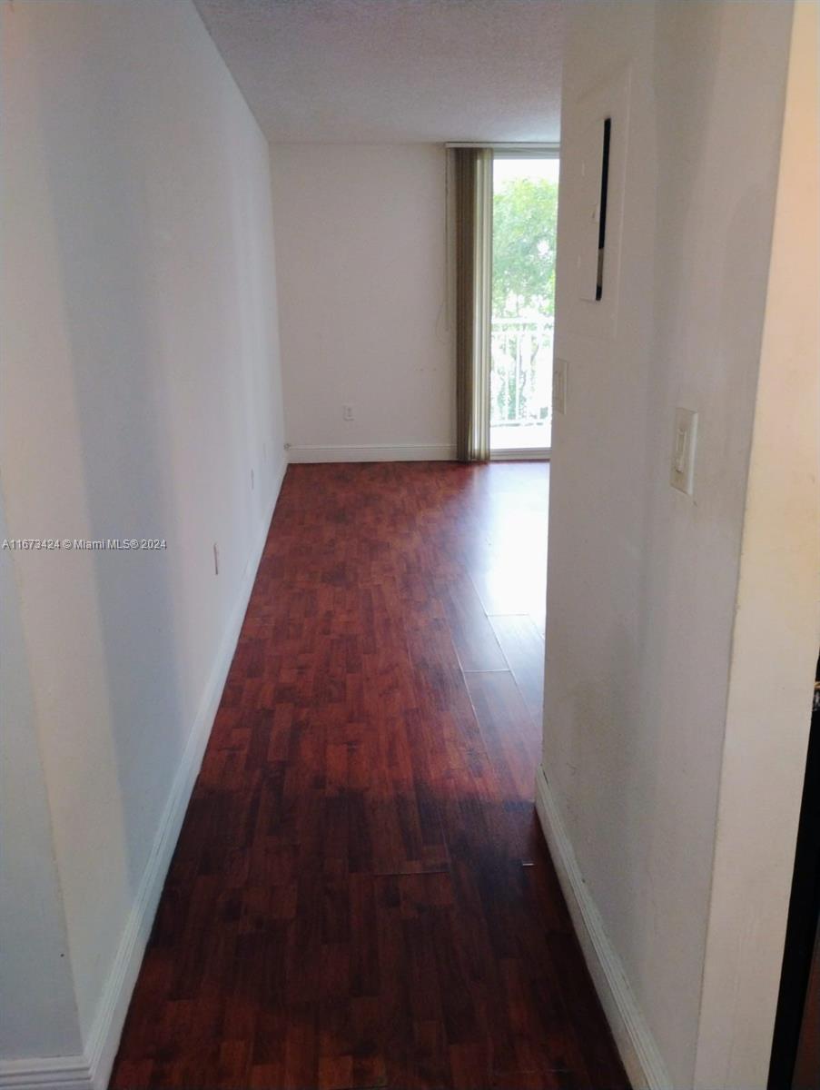 a view of a hallway with wooden floor and a window