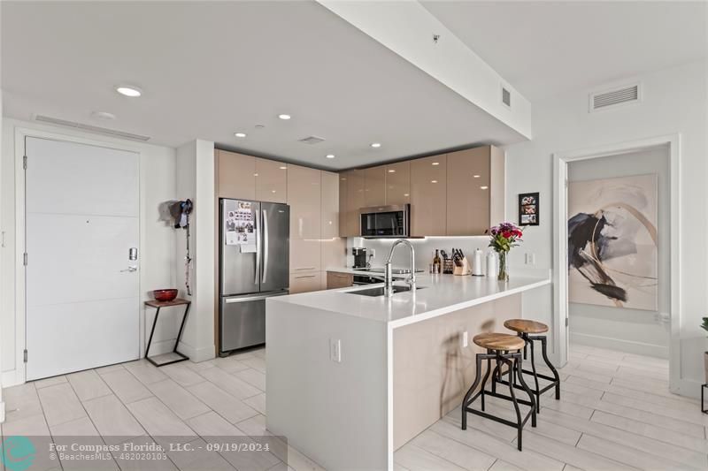 a view of a kitchen with refrigerator and dining table