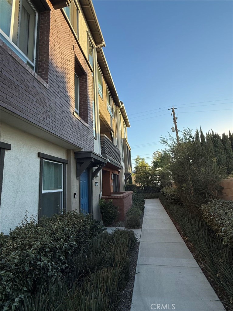 a view of a house with brick walls and plants