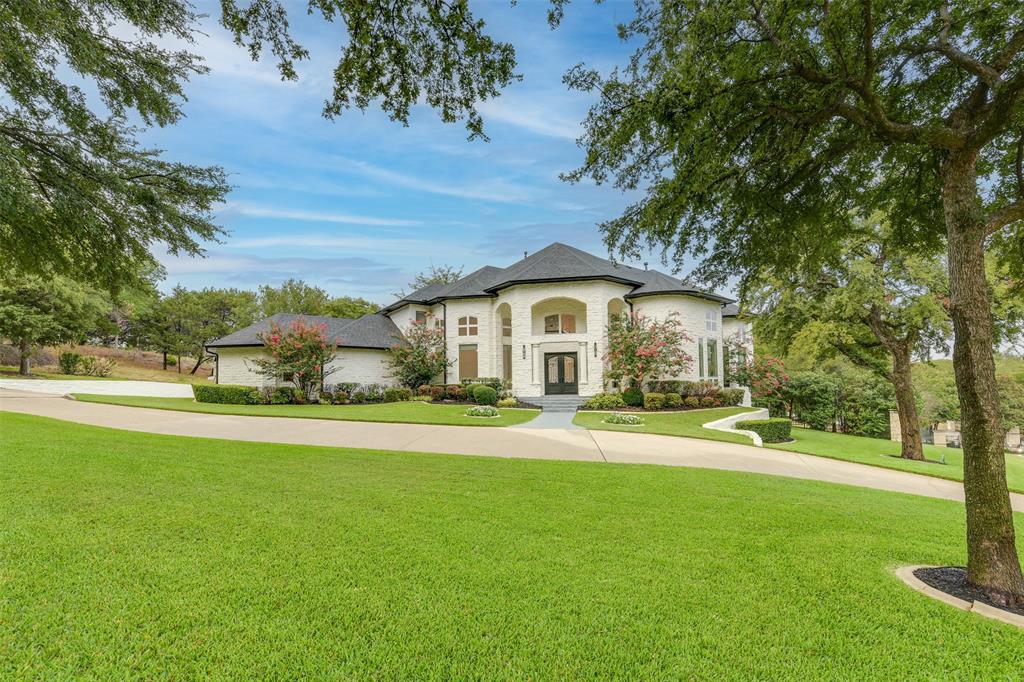 a front view of a house with a yard and trees