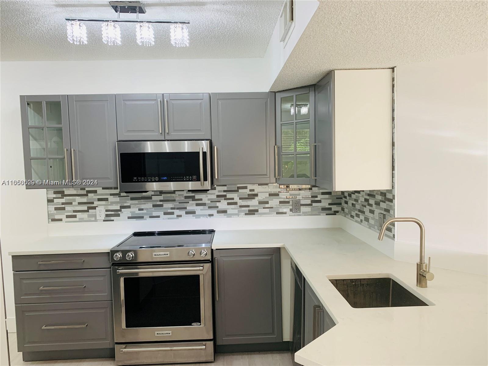 a kitchen with a sink and a stove top oven with wooden floor