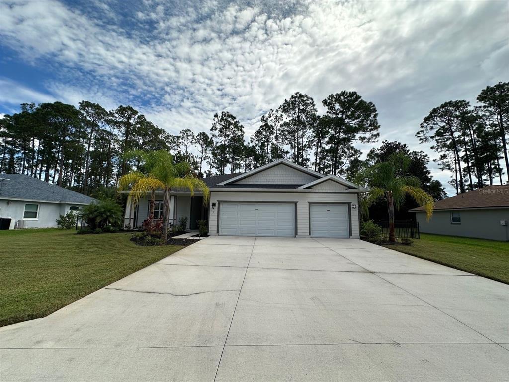 front view of house with a yard and trees