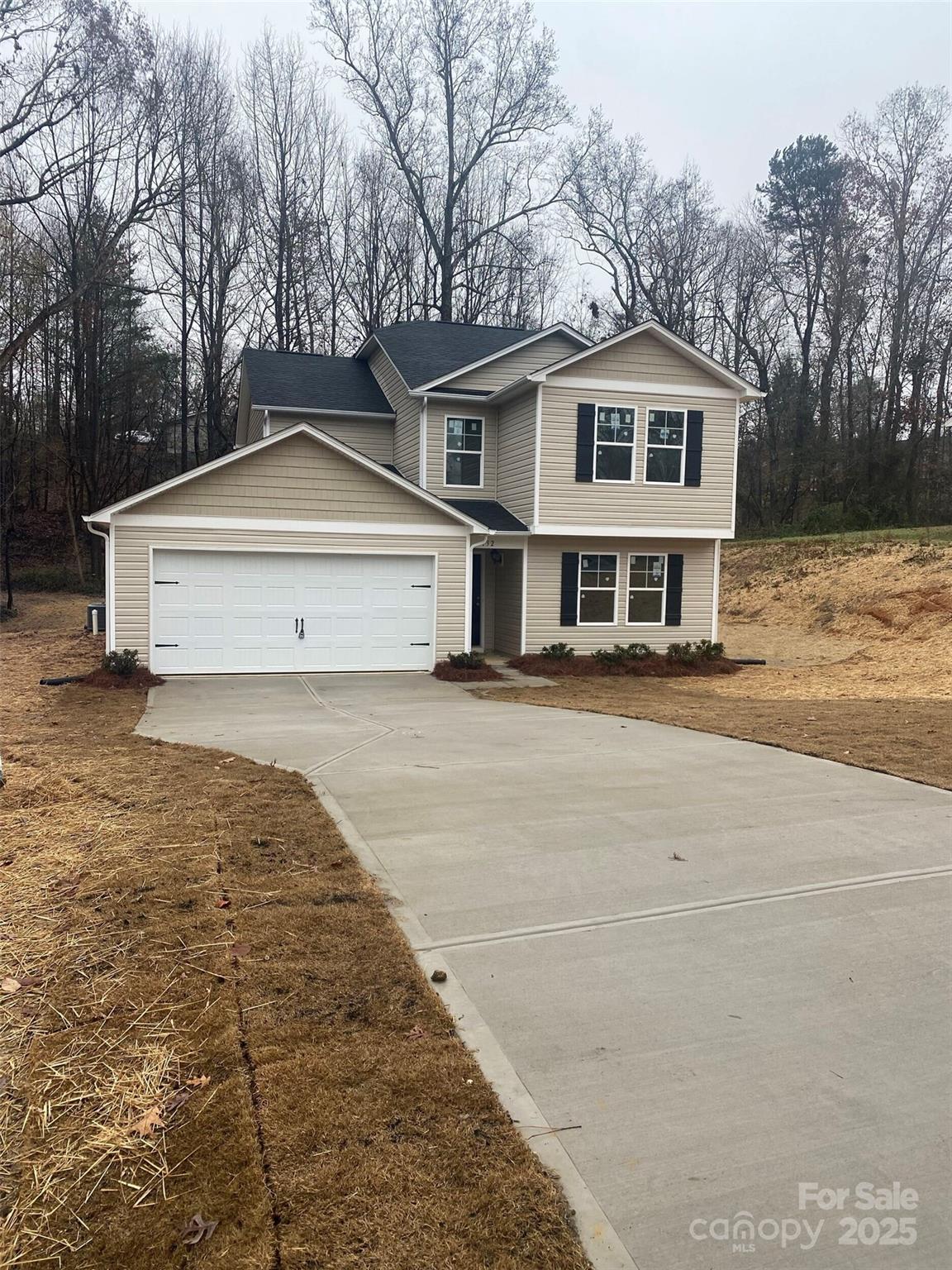 a front view of a house with a yard and trees