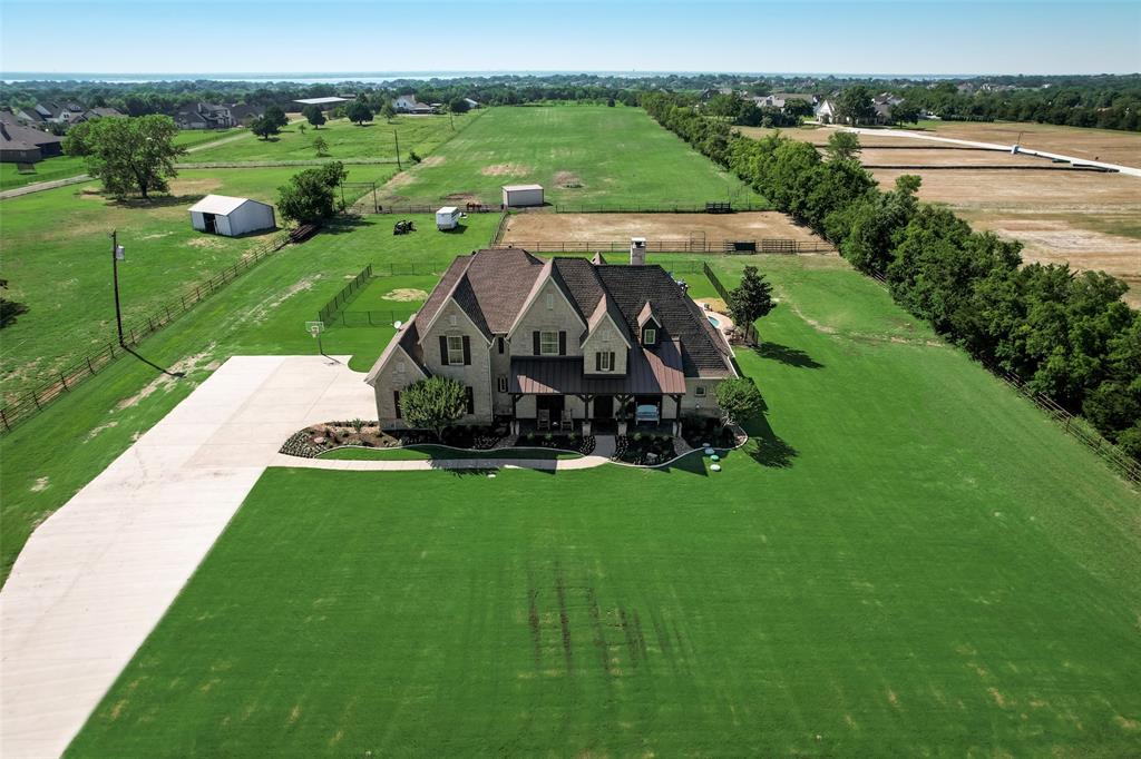 an aerial view of a house with yard and green space