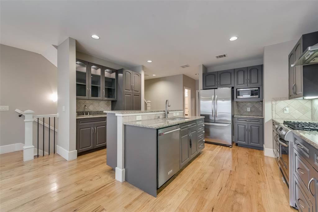 a kitchen with stainless steel appliances kitchen island granite countertop a stove and a refrigerator