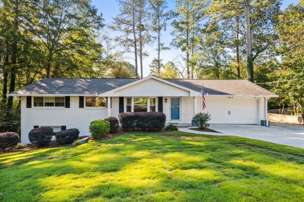 a front view of a house with yard and green space