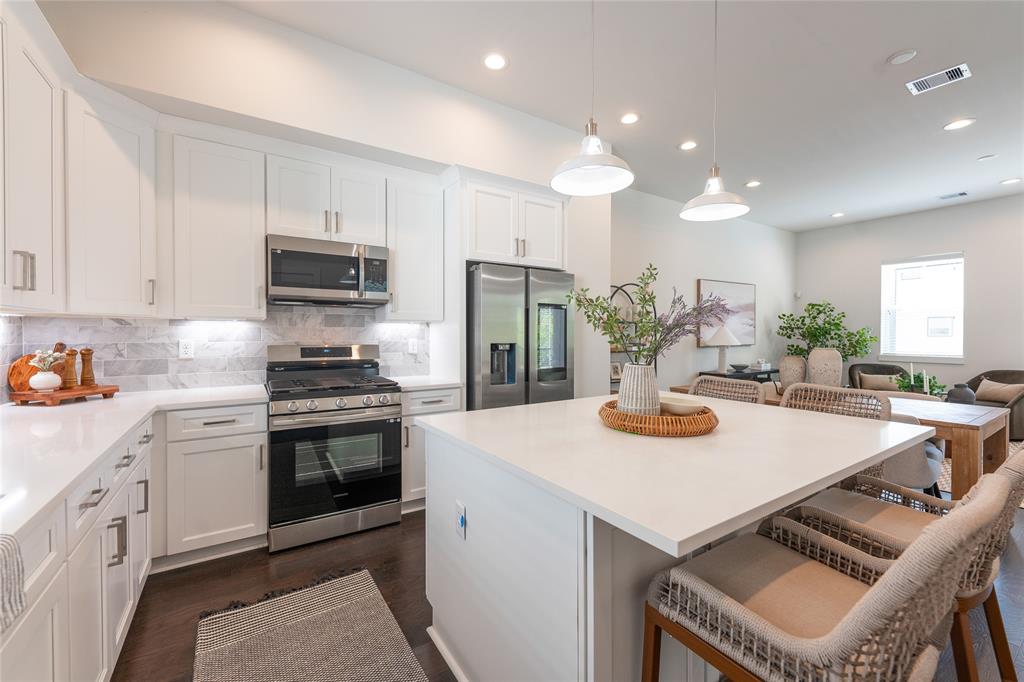 a kitchen with a stove a refrigerator and a dining table