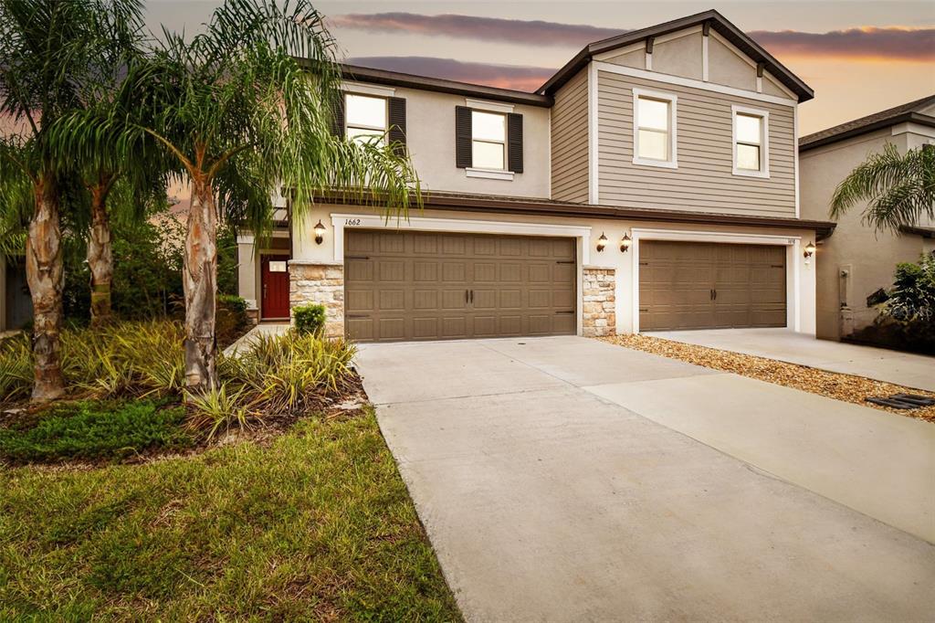 a front view of a house with a yard and garage