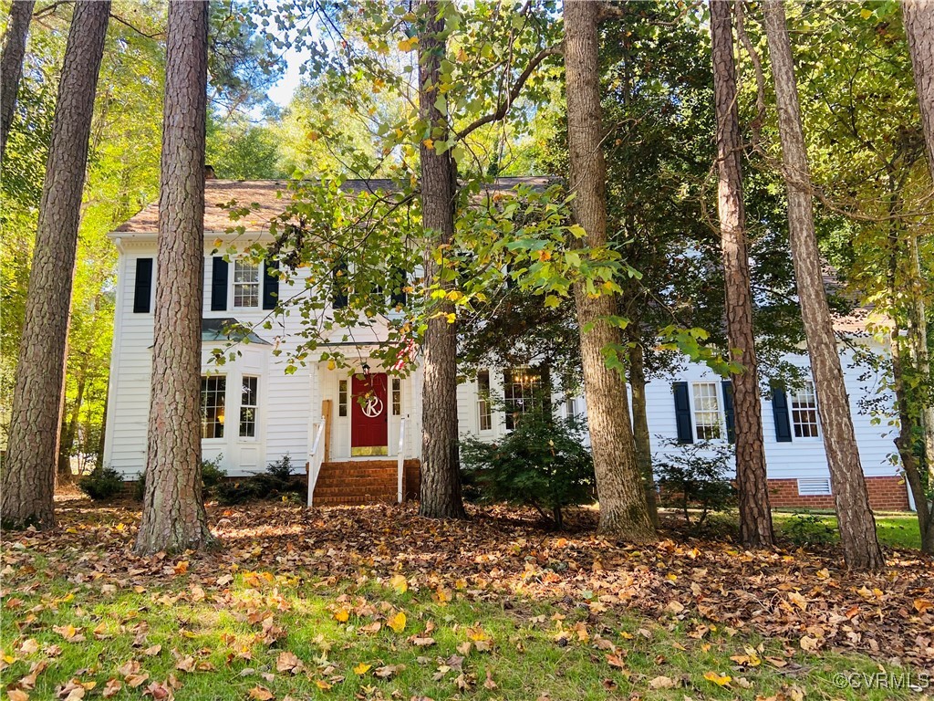 a view of a house with a tree next to a yard