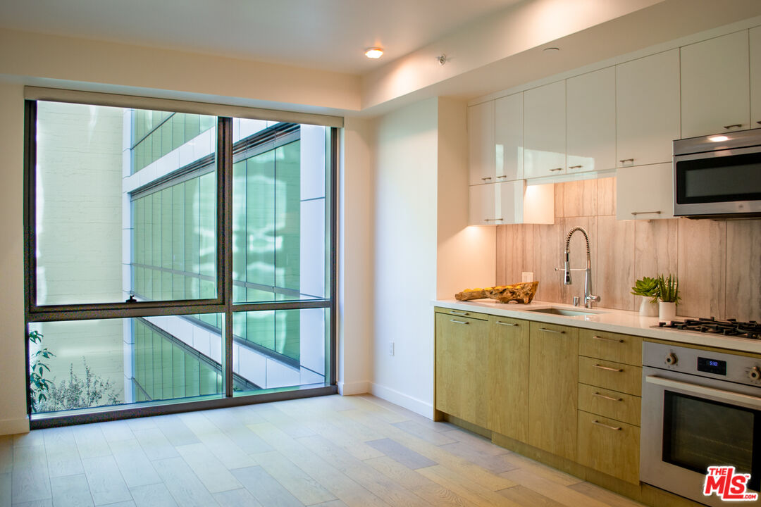 a kitchen with stainless steel appliances wooden cabinets and a large window