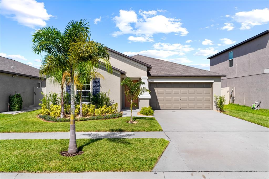 a front view of a house with a yard and garage