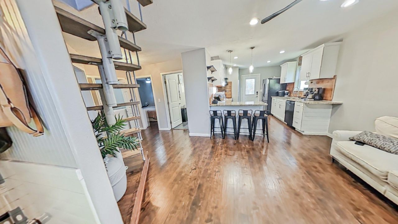 a living room with furniture and a wooden floor