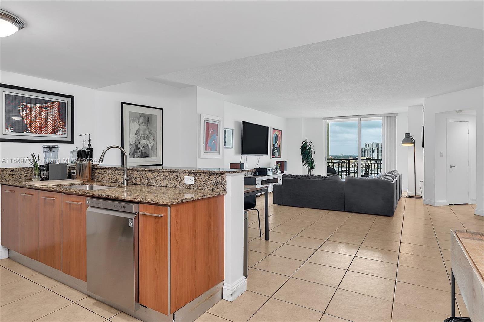 a large living room with stainless steel appliances granite countertop a sink and cabinets