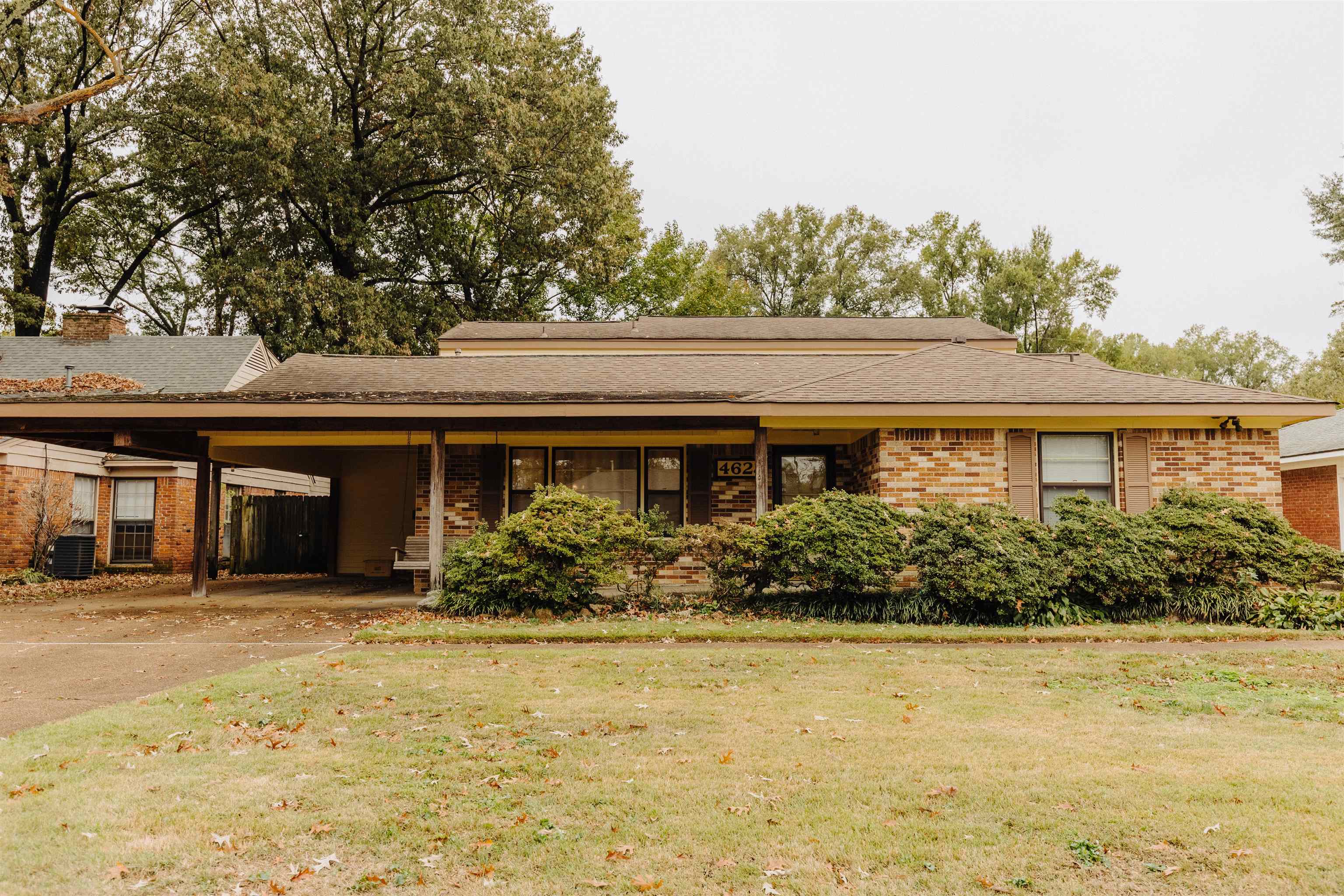 a front view of house with yard and trees in the background