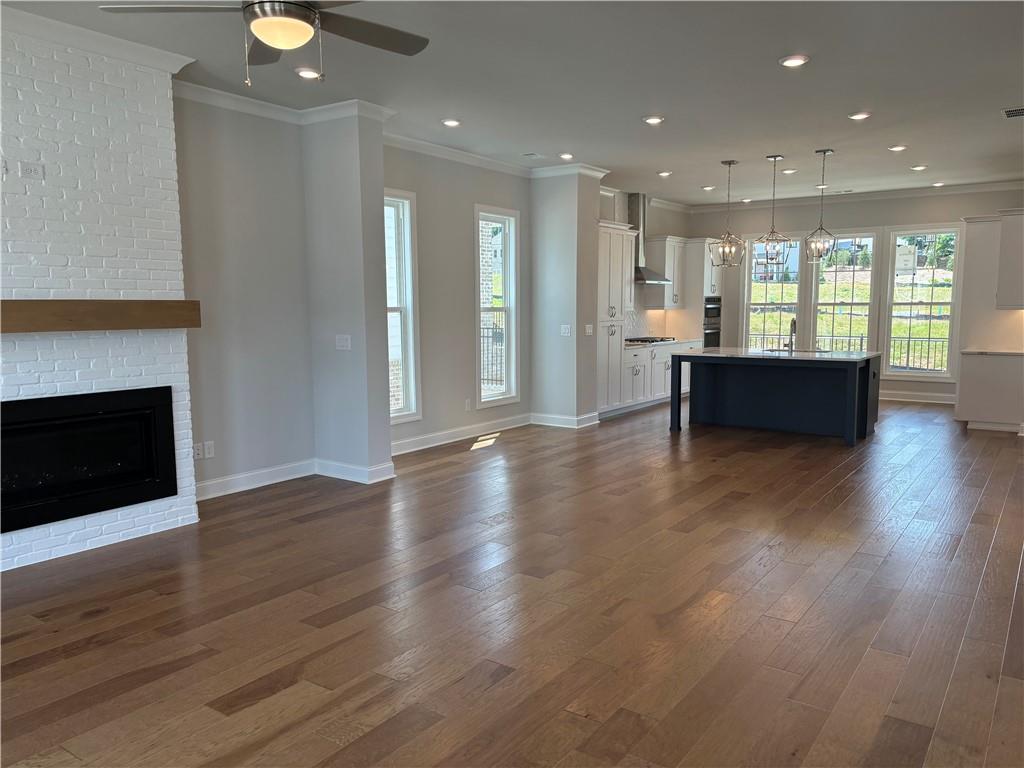 a view of an empty room with wooden floor and a fireplace