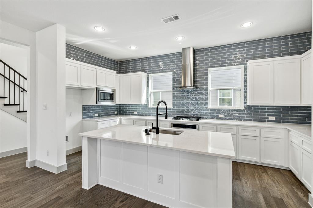 a kitchen with kitchen island granite countertop a sink stainless steel appliances and cabinets