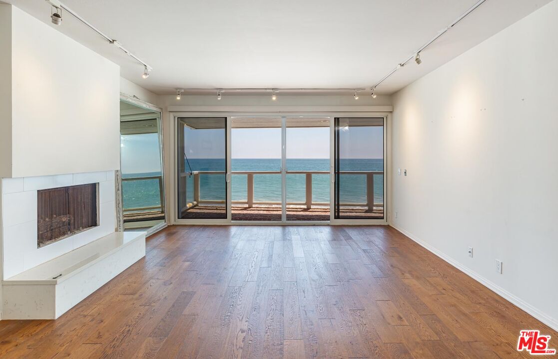 an empty room with wooden floor and window