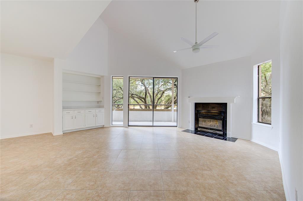 an empty room with windows and fireplace