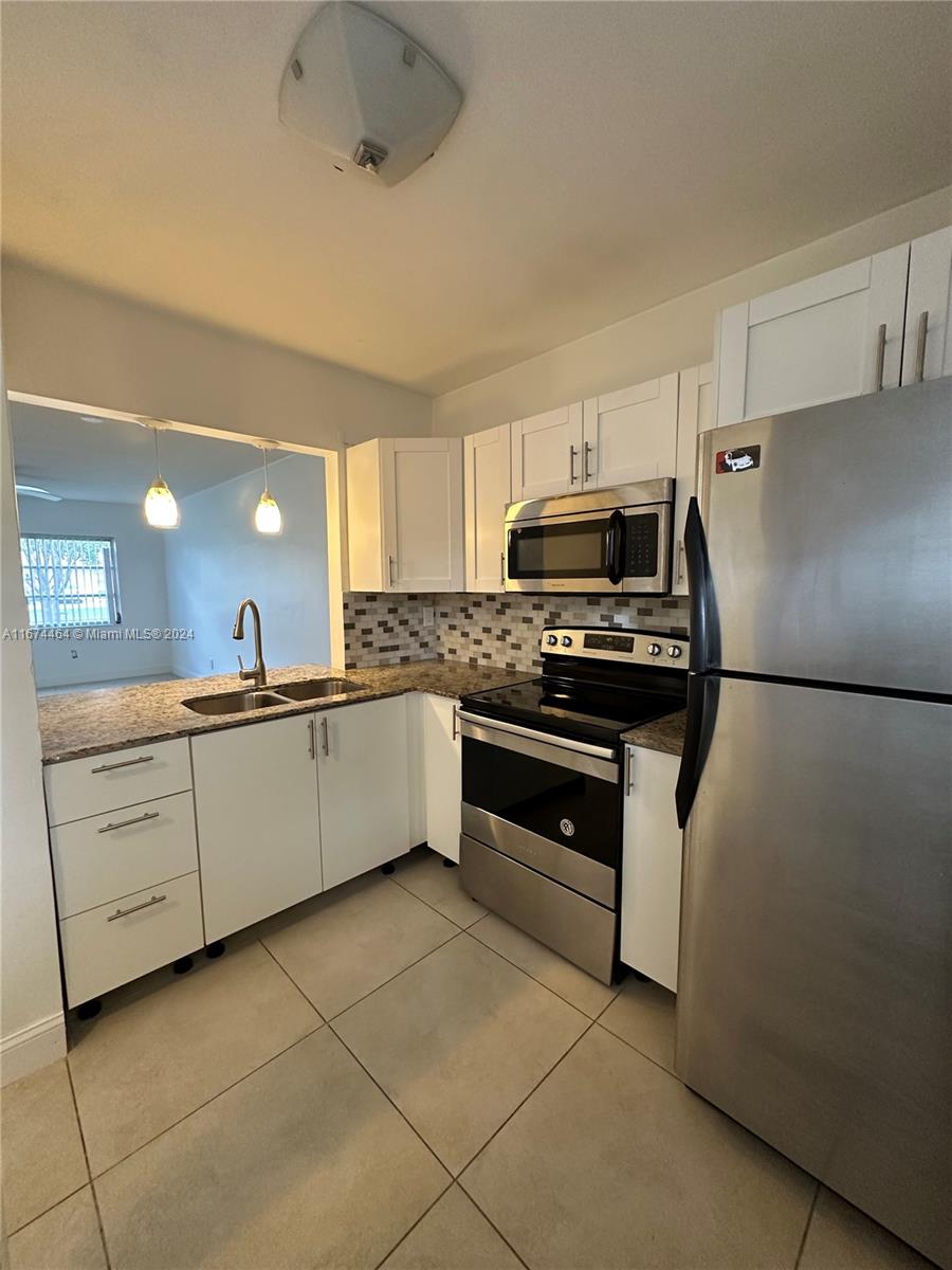 a kitchen with cabinets stainless steel appliances and a window