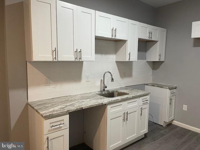 a kitchen with granite countertop a sink a stove and cabinets