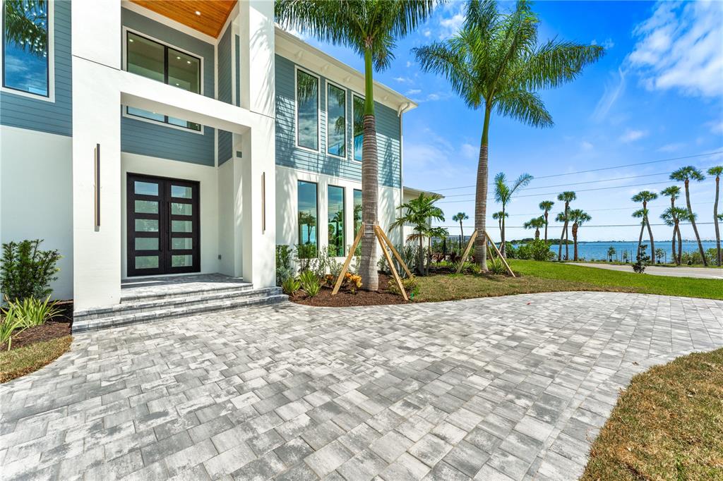 a view of a house with a yard and palm trees