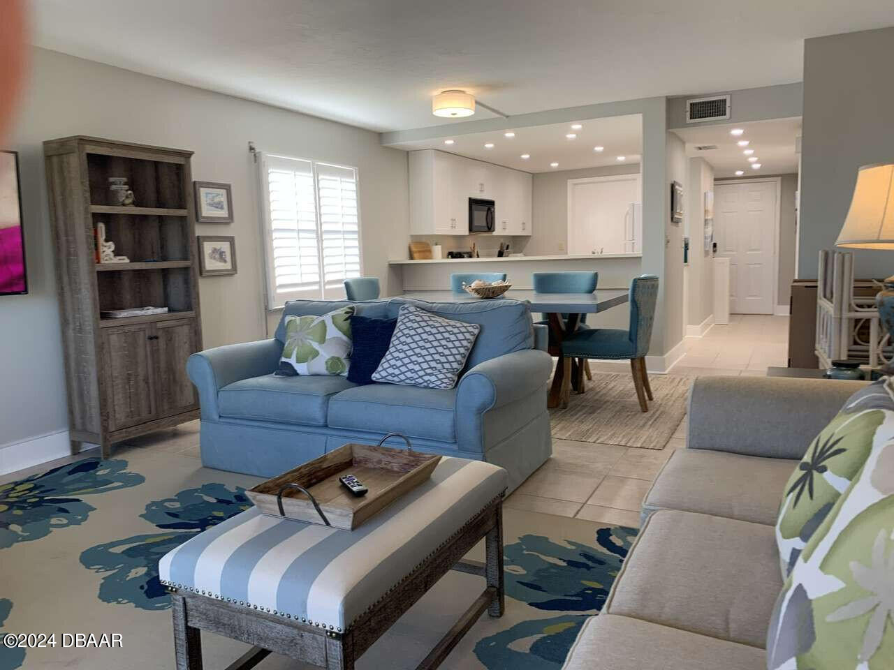 a living room with furniture kitchen view and a window