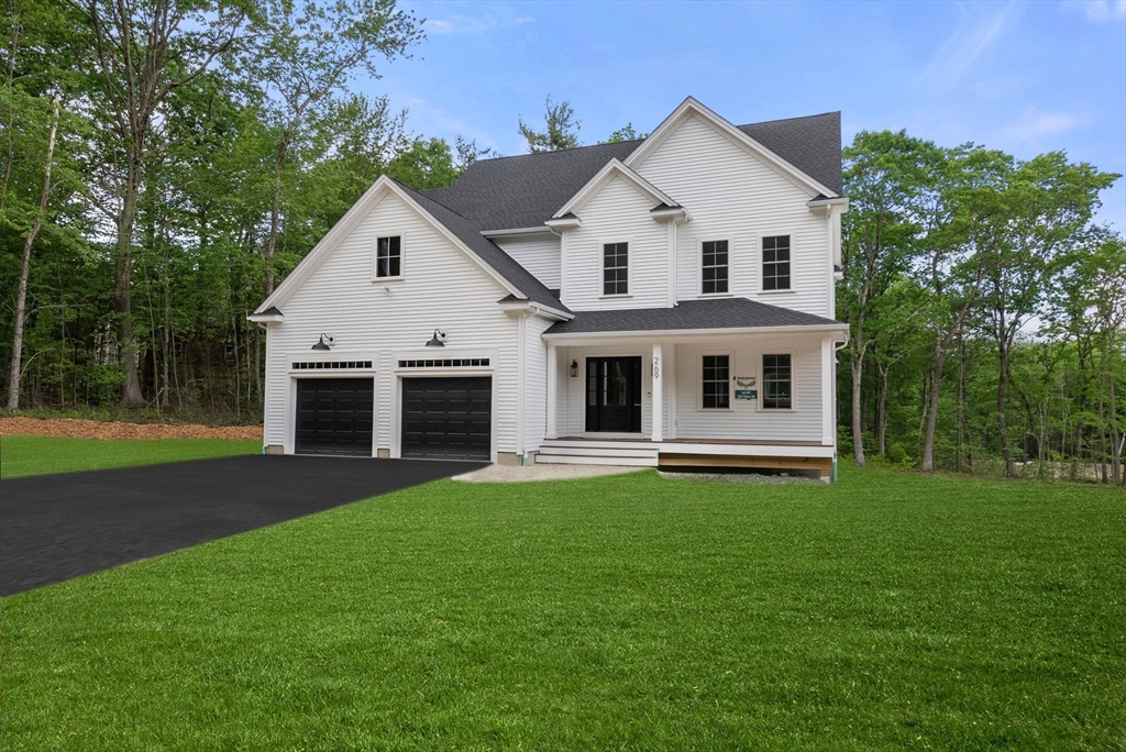 a front view of a house with a garden and yard