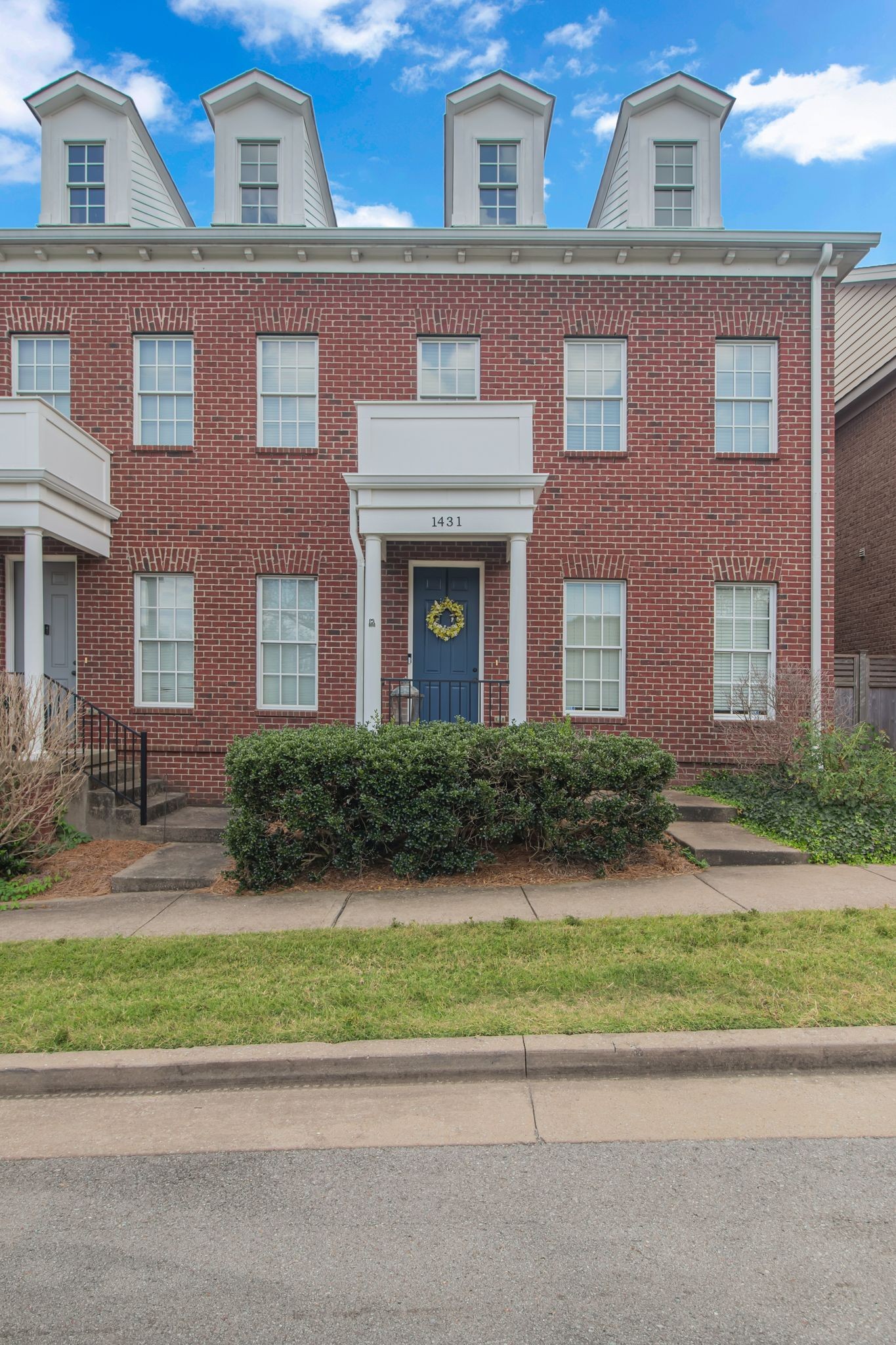 front view of a brick house next to a yard