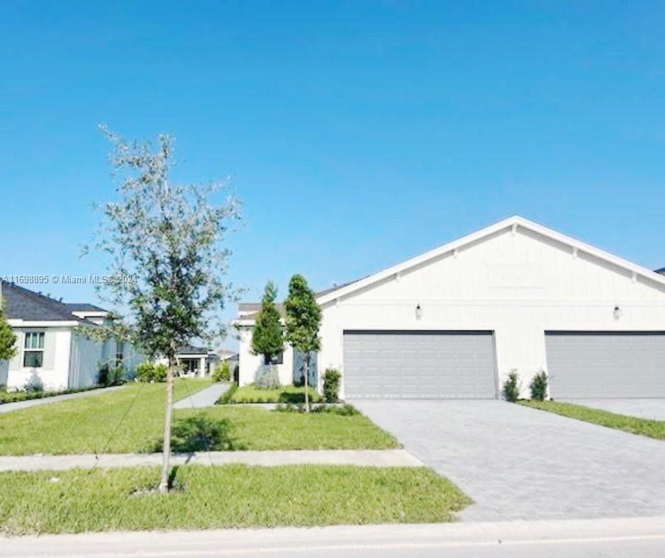 a front view of a house with a yard and garage