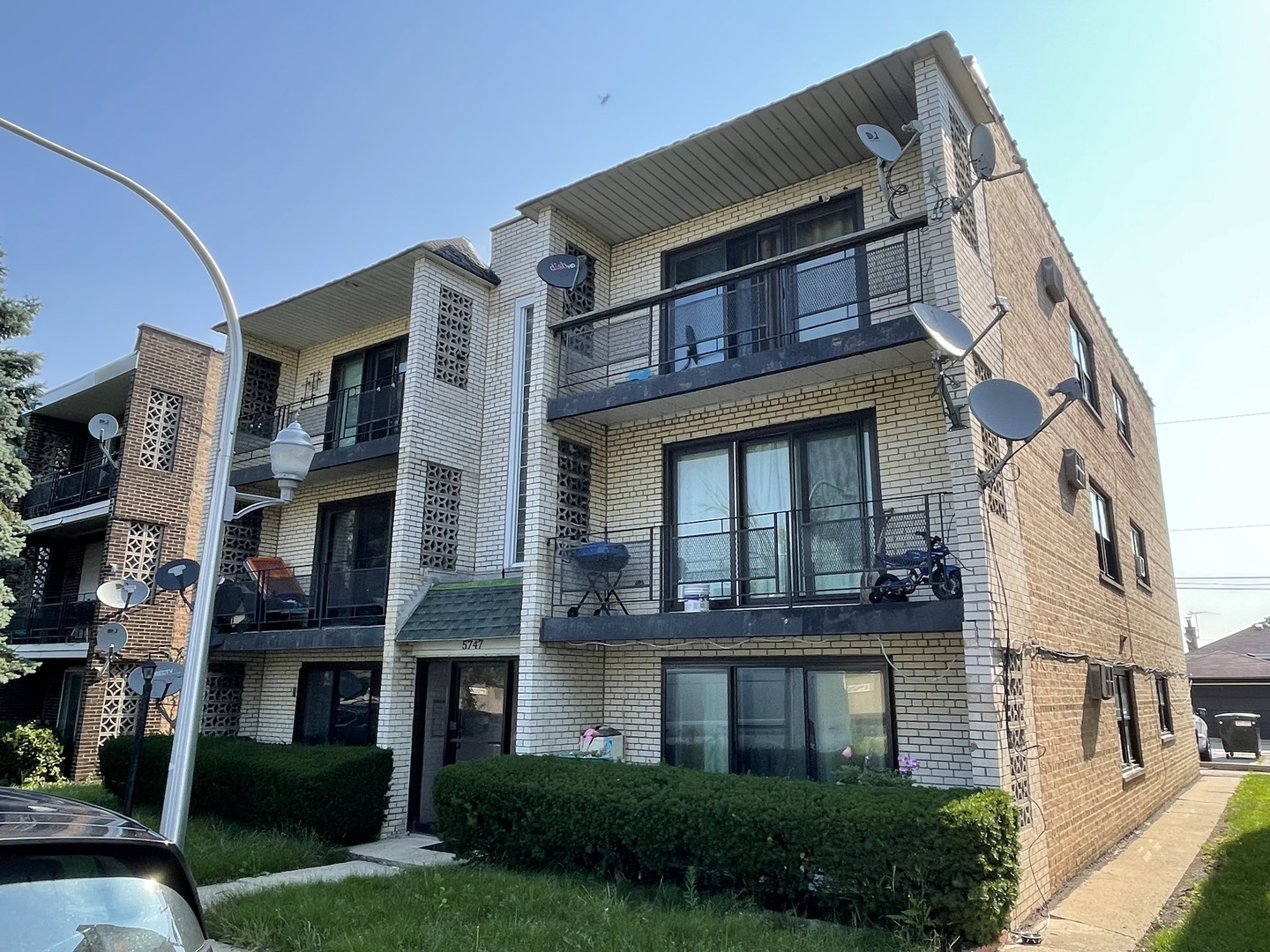 a front view of a residential apartment building with a yard