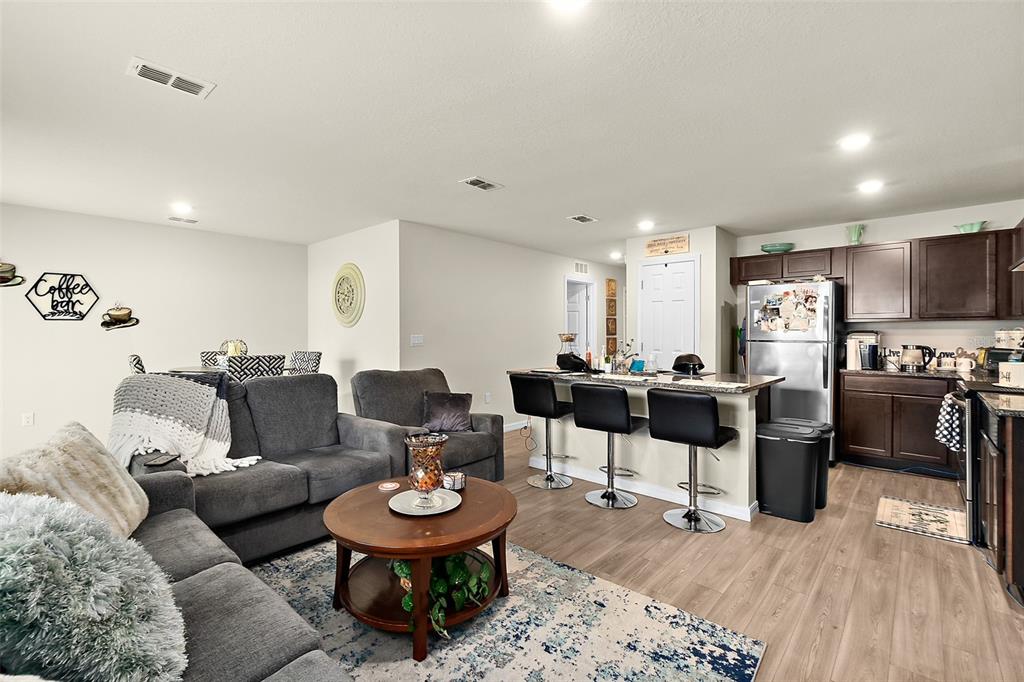 a living room with lots of furniture and kitchen view