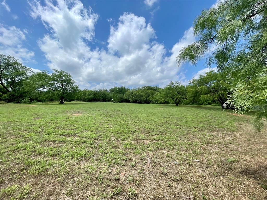 a view of a green field with wooden fence