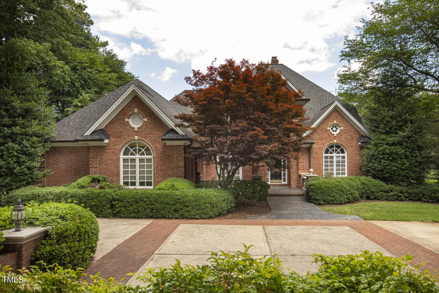 a front view of a house with a yard and trees