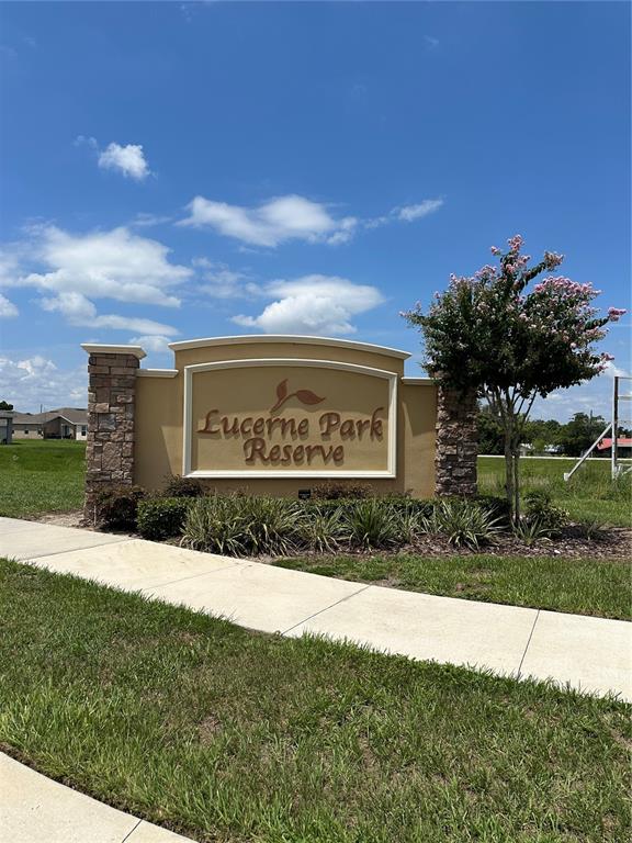 a sign board with a house in the background